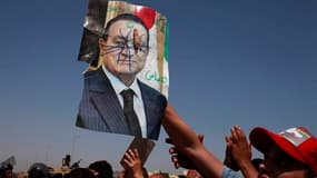 Portrait de Hosni Moubarak brandi par un manifestant devant le tribunal du Caire où était jugé l'ancien président égyptien. Hosni Moubarak a été condamné samedi à la prison à vie. /Photo prise le 2 juin 2012/REUTERS/Suhaib Salem
