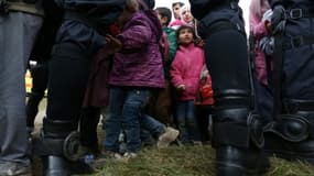 Des enfants parmi les migrants sont encadrés par des policiers slovènes, le 22 octobre 2015 près du village de Rigonce en Slovénie.