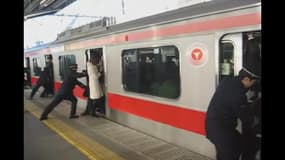 A Tokyo, les "pousseurs" sont là pour faire entrer les passagers dans les wagons bondés.