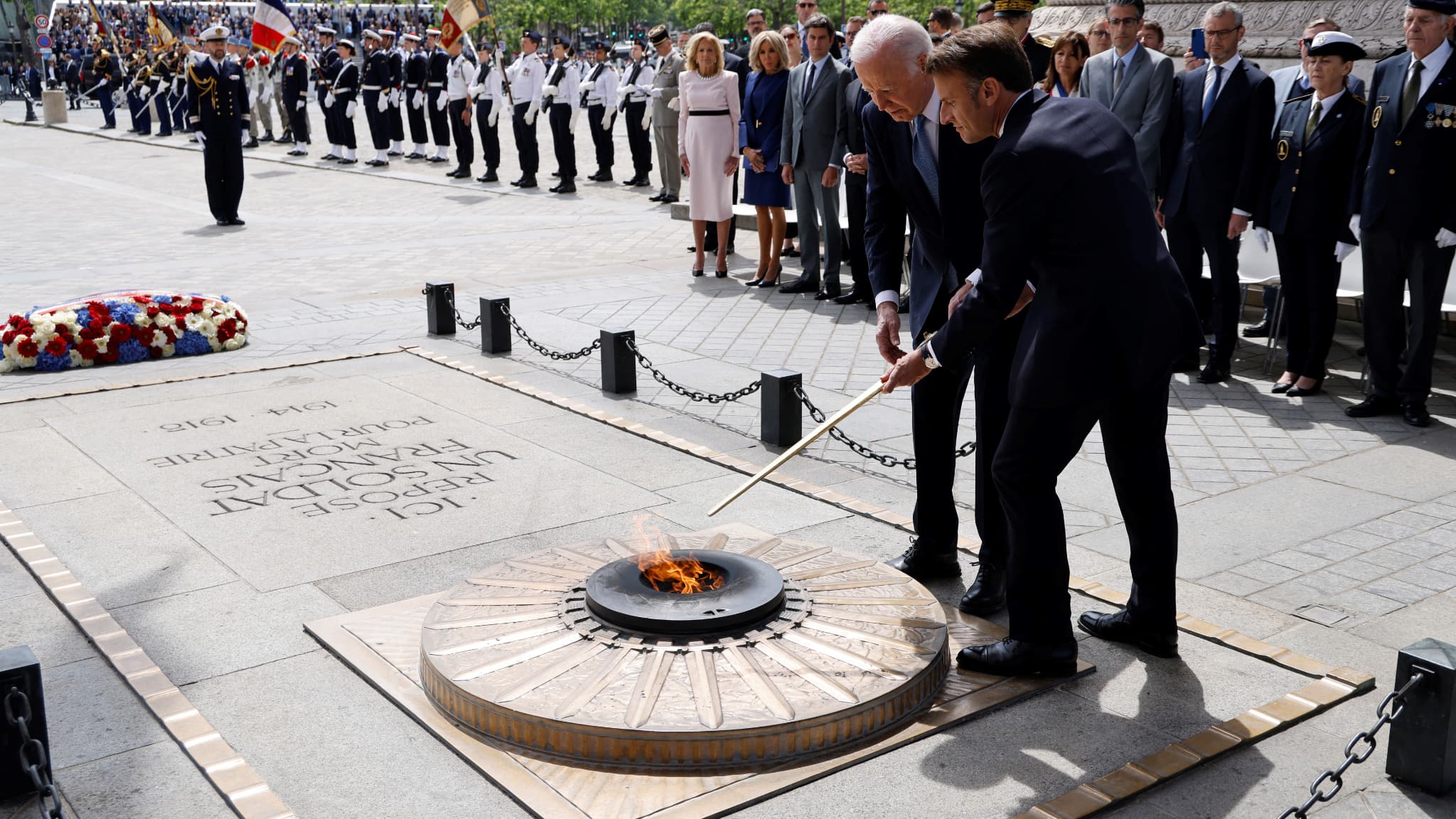 Le président français Emmanuel Macron et le président américain Joe Biden ravivent la flamme de la Tombe du Soldat inconnu lors d'une cérémonie à l'Arc de Triomphe à Paris, le 8 juin 2024.