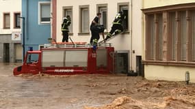 Des pompiers pénètrent dans une maison indonée par les fenêtres du premier étage, le 15 juillet 2021 à Trier, dans l'ouest de l'Allemagne