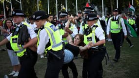 Un manifestant est emmené par des policiers lors d'une manifestation intitulée « Lift The Ban » (Lève l'interdiction) en soutien au groupe interdit Palestine Action, qui réclame la levée de l'interdiction récemment imposée, sur Parliament Square, dans le centre de Londres, le 9 août 2025.