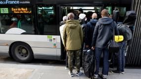 Des voyageurs tentent d'entrer dans un bus bondé à la Gare de Montparnasse, à Paris le 18 février 2022