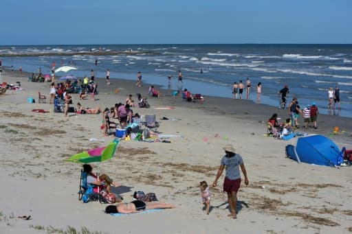 Des personnes profitent du beau temps sur une plage de Galveston, le 2 mai 2020 au Texas Des personnes profitent du beau temps sur une plage de Galveston, le 2 mai 2020 au Texas
