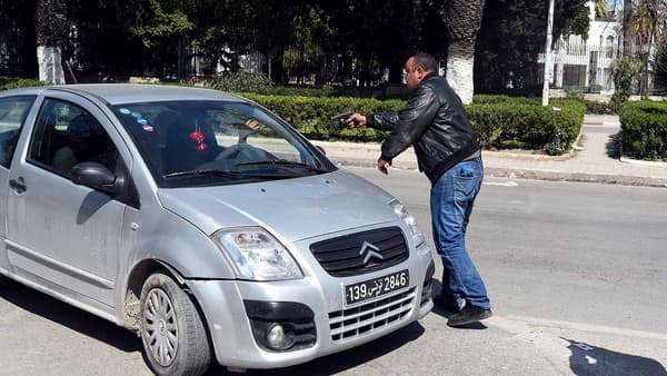 Un policier tunisien en civil arrête un véhicule en le menaçant de son arme à proximité du musée.