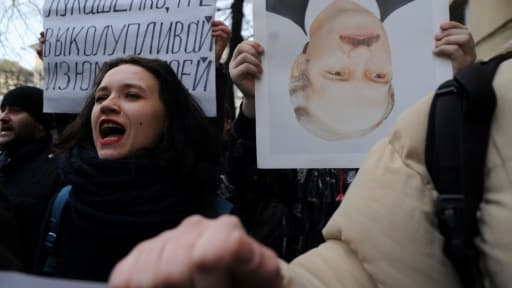 Des opposants brandissent à Minsk, le 15 mars 2017, un portrait tête renversée du président Alexandre Loukachenko, à l'origine d'un projet de taxe contre le "parasitisme social" des gens travaillant moins de six mois par an et suspendu d... Des opposants brandissent à Minsk, le 15 mars 2017, un portrait tête renversée du président Alexandre Loukachenko, à l'origine d'un projet de taxe contre le "parasitisme social" des gens travaillant moins de six mois par an et suspendu d...