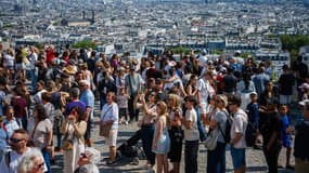 Des touristes au pied de la basilique du Sacré-Coeur à Montmartre, le 5 août 2025 à Paris