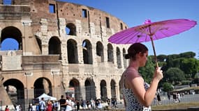 Une touriste en train de s'abriter sous une ombrelle près du Colisée à Rome fin juillet 2021.