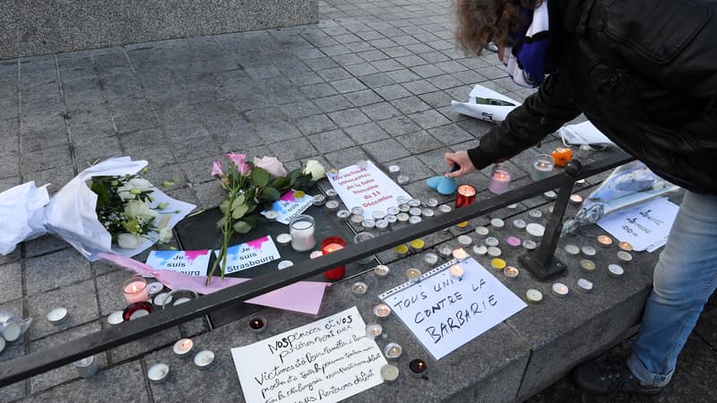 Des passants déposent fleurs et bougies en hommage aux victimes de l'attentat de Strasbourg, le 12 décembre 2018. 