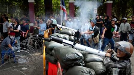 Barricade de fortune érigée par des "chemises rouges" dans le centre de Bangkok, où la situation est explosive après une nuit d'affrontements entre soldats et manifestants antigouvernementaux qui ont fait un mort et neuf blessés, dont un chef militaire de