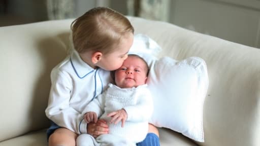 La princesse Charlotte dans les bras de son frère George à Norfolk, en mai 2015