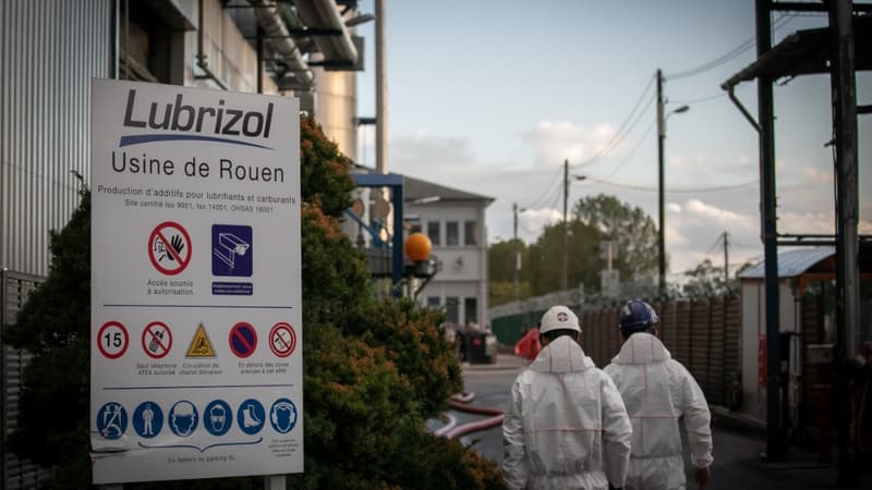 Deux travailleurs marchent vers l'usine Lubrizol près de Rouen, le lendemain de l'incendie