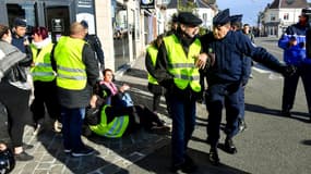 Des forces de l'ordre évacuent des manifestants vêtus d'un gilet jaune dans le cadre d'un rassemblement contre la hausse des prix des carburants, le 9 novembre 2018 à Albert, dans la Somme. 