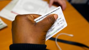 Une femme tient sa carte d'aide médicale d'État dans sa main, à Bron, près de Lyon, en 2024.