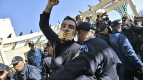 Un policier algérien maîtrise un manifestant lors du sit-in organisé par des journalistes à Alger, le 28 février 2019