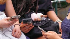 Des enfants utilisent leurs téléphones alors qu'une nouvelle législation australienne restreignant l'accès aux réseaux sociaux pour les moins de 16 ans entre en vigueur à Sydney, en Australie, le 10 décembre 2025. 