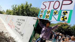 Un homme portant une pancarte sur le site de Bure, où doit être installé un site d'enfouissement de déchets nucléaires, le 14 août 2016.