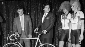 Dans cette photographie d'archives prise le 2 février 1984, le cycliste français Bernard Hinault  et son sponsor l'homme d'affaires français Bernard Tapie présentent la nouvelle équipe cycliste "La Vie Claire" avec des danseuses du cabaret Crazy Horse à Paris. 