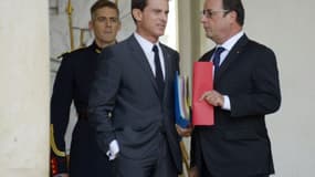 Le président français François Hollande (d) et son Premier ministre Manuel Valls (c) sur le perron de l'Elysée à Paris, le 23 septembre 2015