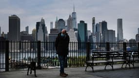 Un homme portant un masque et  promenant son chien à New York le 23 avril 2020