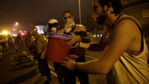 La population forme une chaîne humaine pour aider les pompiers dans leur lutte contre les incendies, le 15 octobre 2017 à Vigo, en Espagne