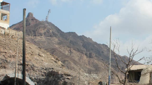 Des hommes armés à Aden près des décombres en janvier 2016, après l'attentat à la bombe à proximité de la résidence du chef de la police Shalal Shaea.