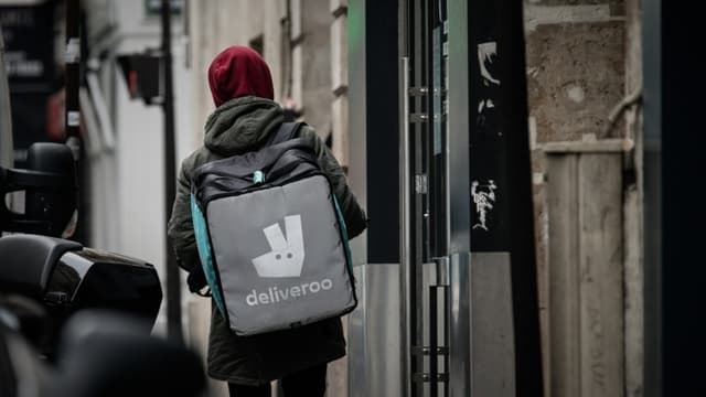 Un livreur pour la plateforme Deliveroo cherche une adresse à Paris, le 8 mars 2020