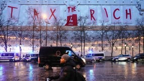 Plusieurs dizaines de militants d'Attac ont déployé une banderole "Tax the Rich" samedi 24 février depuis le haut de la façade du futur hôtel LVMH sur les Champs-Elysées.