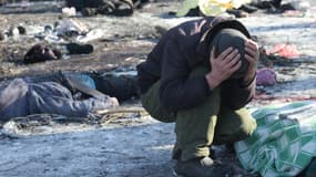 Un homme pleure à côté du corps de sa femme tuée à la suite d'une frappe de missile à Donetsk le 21 janvier 2024, au milieu du conflit russo-ukrainien en cours.