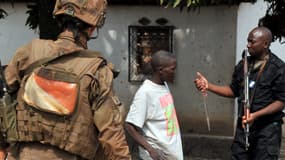 Un soldat français de l'opération Sangaris et un gendarme centrafricain confisquent un couteau à un homme, à Bangui le 9 février.