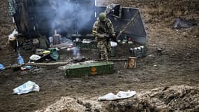 Un soldat ukrainien près d'un feu de camp sur la ligne de front au nord-est de Kiev ce jeudi.