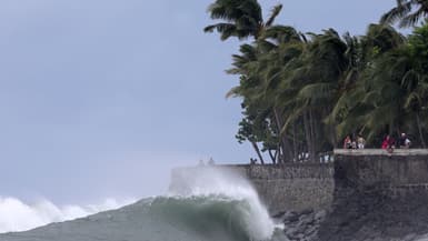 Des piétons se tiennent au-dessus de la houle sur la côte à l'approche du système tropical "Garance" à Saint-Denis de la Réunion, sur l'île de La Réunion, territoire français d'outre-mer, le 26 février 2025.