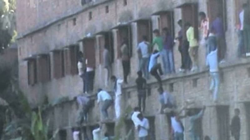 Des dizaines de personnes en train d'escalader les murs d'un centre scolaire dans l'Etat de Bihar en Inde