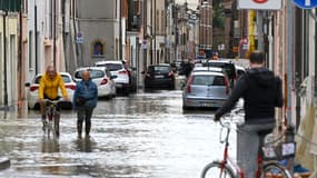 Des habitants à vélo dans une rue inondée de Lugo, en Italie, le 18 mai 2023