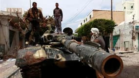 Des insurgés libyens sur un véhicule des forces pro-Kadhafi. Les forces libyennes pro-Kadhafi qui assiègent la cité portuaire de Misrata ont reçu l'ordre de se retirer, a indiqué samedi un soldat libyen blessé capturé par les rebelles qui tiennent toujour