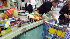 Un caissier avec une cliente dans un supermarché d'Hazebrouck, dans le Nord, le 15 mars 2012.