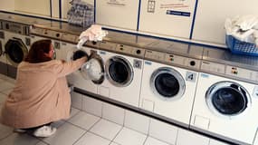 Une femme fait la lessive dans un lavomatic, à Caen. En France, le nombre de mères élevant seule leurs enfants à augmenté de 30% depuis le début des années 90. 