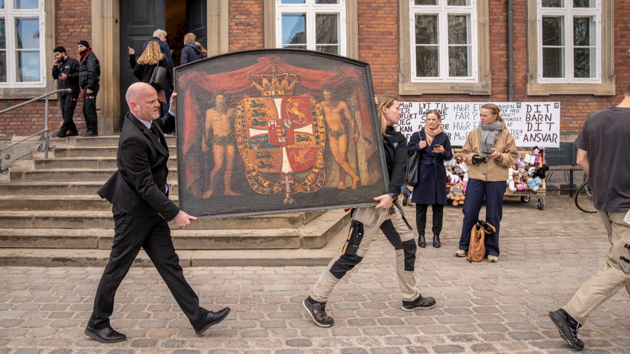 Des personnes transportent des tableaux historiques hors du bâtiment en feu, alors que la Bourse brûle à Copenhague, au Danemark, le 16 avril 2024. 