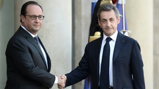 Le président français François Hollande (g) salue son prédécesseur à l'Elysée Nicolas Sarkozy à Paris le 15 novembre 2015