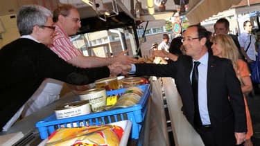 François Hollande sur le marché de Tulle. L'actuel chef de l'Etat a rencontré samedi à la mi-journée pendant trois quarts d'heure l'ancien président Jacques Chirac en son château de Bity, à Sarran, en Corrèze. /Photo prise le 21 juillet 2012/REUTERS/Pierr