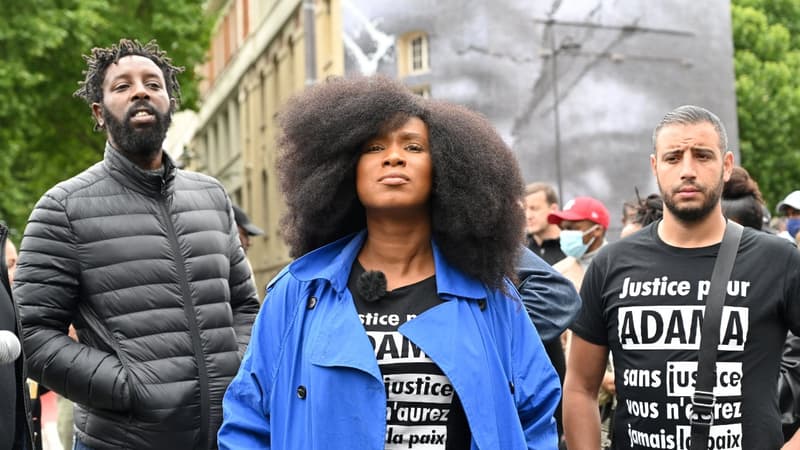 La soeur d'Adama Traoré accompagnée du réalisateur Ladj Ly pose devant un collage de JR en hommage à son frère à Paris, le 9 juin 2020