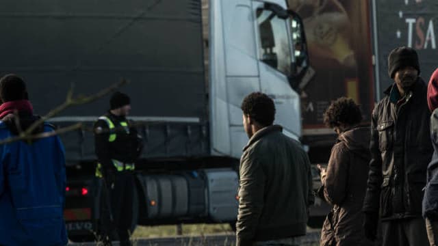 La gendarmerie face à plusieurs migrants sur l'A16 près de Calais, après qu'ils aient tenté de monter à bord de camions le 21 janvier 2016. -
