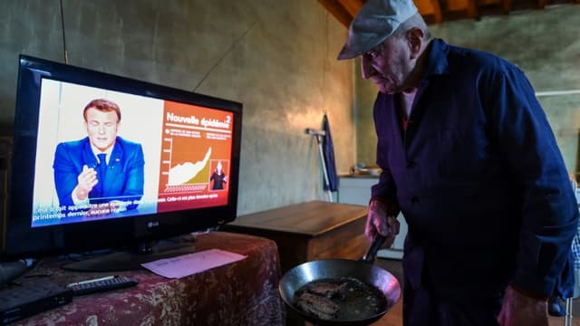 Un homme prépare son dîner en regardant l'allocution du président Emmanuel Macron le 31 mars 2021 à Happonvilliers (France) 
