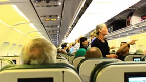 Des passagers en train de s'installer à bord d'un avion.