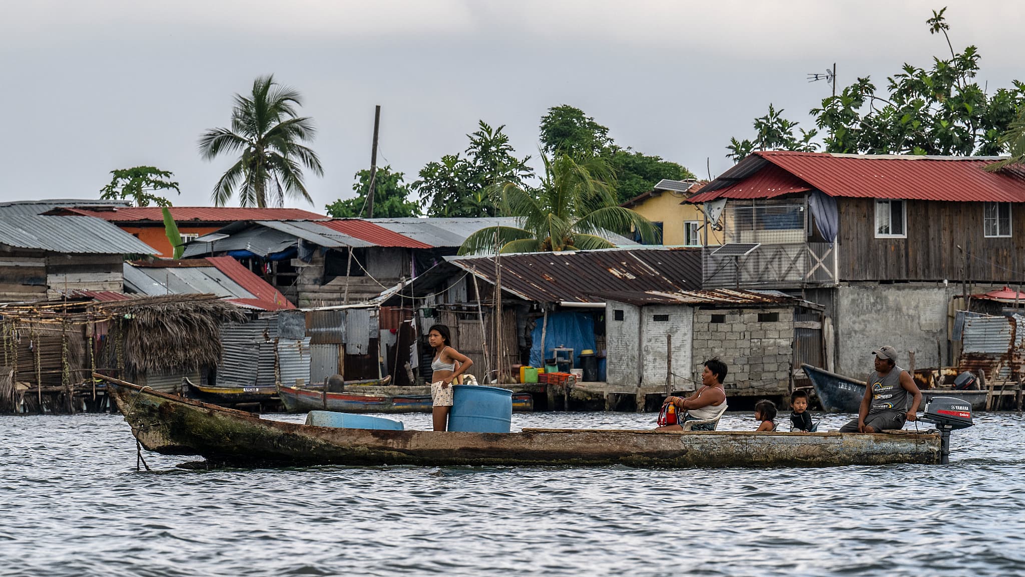 Un homme transporte sa famille sur un bateau sur l'île de Carti Sugtupu, dans la comarque indigène Guna Yala, au Panama, dans la mer des Caraïbes, le 30 août 2023