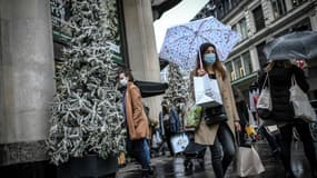 Des passants portant le masque contre le Covid-19 dans une rue de Paris, le 24 décembre 2020