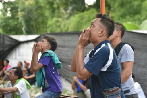 Des hommes encouragent leurs oiseaux pendant un concours de chant à Jakarta, le 7 janvier 2016 Des hommes encouragent leurs oiseaux pendant un concours de chant à Jakarta, le 7 janvier 2016