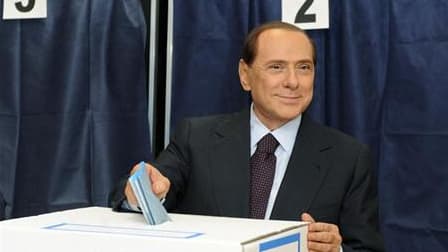 Silvio Berlusconi dans un bureau de vote à Milan. Le chef du gouvernement italien se dit "surpris et peiné" par les résultats du premier tour des élections locales italiennes, marqué par un net recul du centre droit qui a été notamment devancé à Milan, fi