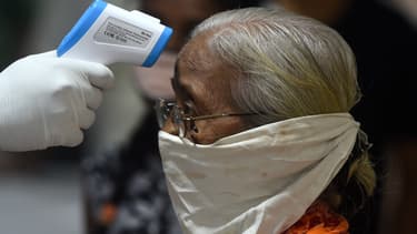Un médecin prend la température d'une femme à Mumbai (Inde), le 10 juillet 2020.