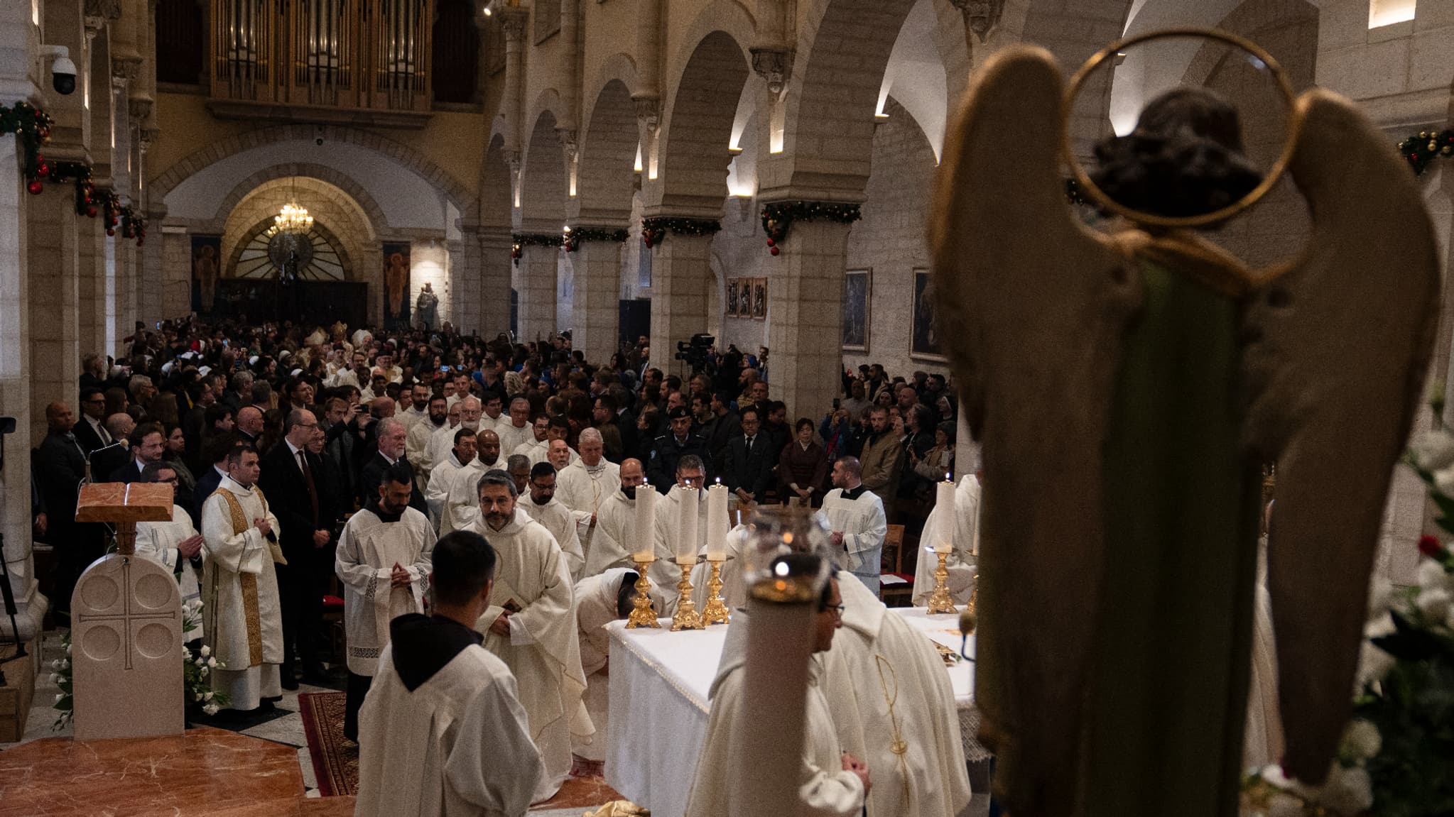 Des membres du clergé arrivent pour la messe de minuit de Noël à l'église de la Nativité dans la ville biblique de Bethléem en Cisjordanie occupée, le 25 décembre 2023.
